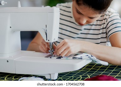 Focused Asian Woman Sewing Some Pollution Masks