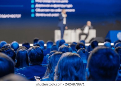 Focused audience at a business conference listening to an expert speaker, embodying professional development. - Powered by Shutterstock