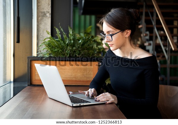 専門のビジネスマンはカフェでノートパソコンを使い 本格的な女性はコーヒーショップでパソコンやノートパソコンを使い フリー ランス オンラインで勉強 インターネットの閲覧 請求書の確認を行う の写真素材 今すぐ編集
