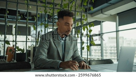 Focused businessman analyzing documents in modern office