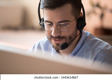 Focused businessman telemarketer telesales agent wear wireless headset make conference video call talk consult online client on computer, male helpline operator work in customer care support office