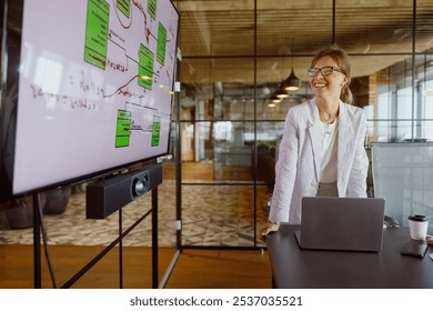 A focused businesswoman delivers an engaging presentation in her stylish office while utilizing various visual aids - Powered by Shutterstock