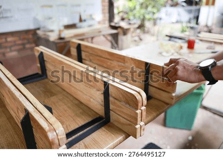 Focused carpenter hand making custom furniture. craft of assembling wood and metal parts in workshop, professional artisan at work building wooden shelf