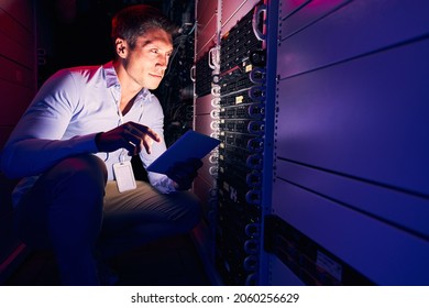 Focused Caucasian system administrator monitoring storage hardware - Shutterstock ID 2060256629