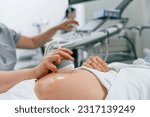 Focused close up view. Pregnant woman is lying down in the hospital, doctor does ultrasound.
