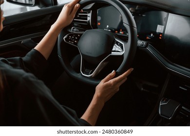 Focused close up view of woman hands that are driving new car. - Powered by Shutterstock