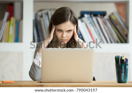 Focused concerned student learning difficult homework assignment with laptop online, concentrated girl preparing for digital exam on pc, serious young woman thinking hard on task with computer