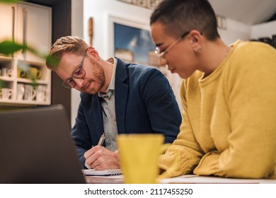 Focused Couple Of Diverse Businesspeople Doing Paperwork Together While Working In Casual Cozy Home Office.