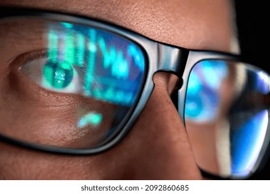 Focused crypto trader analyst wearing eyeglasses working looking at computer screen reflecting in glasses analyzing online trading stock exchange market data charts. Close up eye reflection. - Shutterstock ID 2092860685