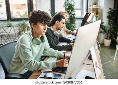 focused curly-haired man editing photos on tablet and looking at monitor in modern startup office - Powered by Shutterstock