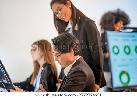 Focused DevSecOps squad working at a bright command center. Professional female cybersecurity manager discussing cloud native security and predictive analytics with team.