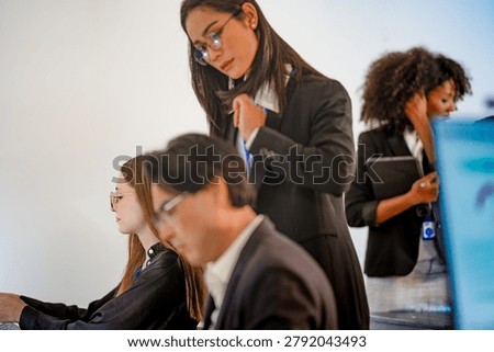 Focused DevSecOps squad working at a bright command center. Professional female cybersecurity manager discussing cloud native security and predictive analytics with team.