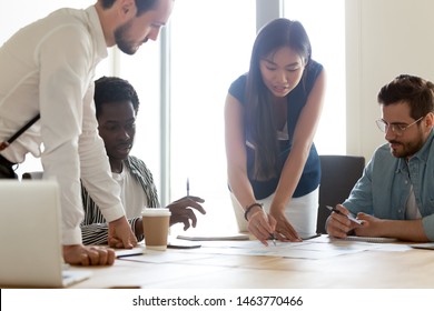 Focused Diverse Business Executive Team People Designers Architects With Female Asian Leader Manager Discuss Paperwork Financial Report Brainstorm Work Together At Group Corporate Office Meeting