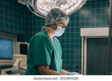 A focused doctor in full surgical attire, including mask, stands prepared to begin a procedure in operating room - Powered by Shutterstock