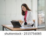 Focused and Efficient: A young professional woman works diligently at her desk, showcasing her dedication and commitment to her tasks.  She exudes confidence and productivity, symbolizing modern workp