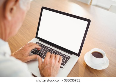 Focused Elderly Man Typing On Laptop At Home