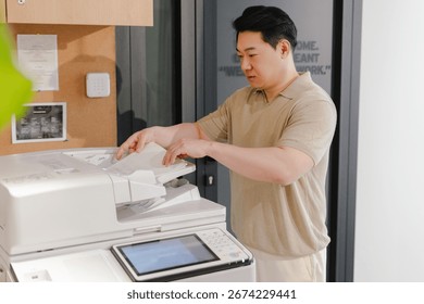 Focused employee using a modern multifunction printer in a contemporary office setting, performing everyday tasks and improving productivity