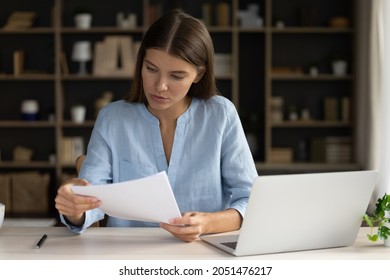 Focused Female Employee Reading Document, Report, Contract Text At Workplace. Business Woman, Student, Homeowner Woman Studying Loan, Insurance Agreement, Bill For Payment, Reviewing Bank Letter