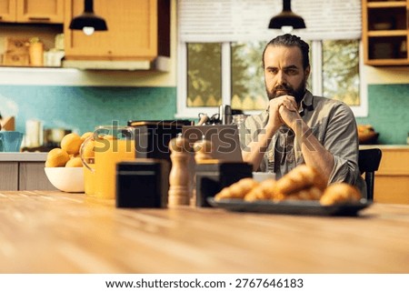 Focused freelancer does nervous tic and cracking knuckles at laptop, working remotely in the kitchen with involuntary movements and nervous habit. Popping sounds from fingers.