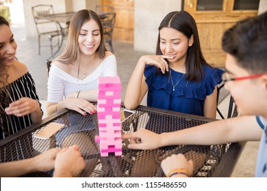 Focused Friends Playing Board Games Together At A Restaurant
