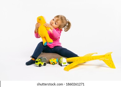 Focused Girl Play With Toys. The Concept Of Gender Stereotypes.White Background.