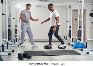 Focused guy using training device during stability workout