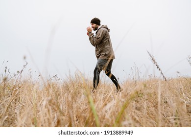 Focused handsome man doing exercise while working out outdoors