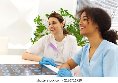 Focused Happy Multiethnic Healthcare Workers Analyzing CT Lung Screening While Working In Medical Clinic Or Hospital, Medical Team Looking Away With X-ray Scan Discussing Diagnosis Or Treatment Option