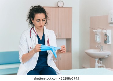 A focused healthcare professional prepares gloves, demonstrating readiness and meticulous care in a clinical environment before patient interaction. - Powered by Shutterstock