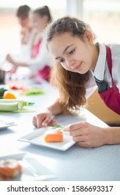 Focused High School Student Plating Food In Home Economics Class