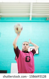 Focused High School Student Playing Netball In Gym Class