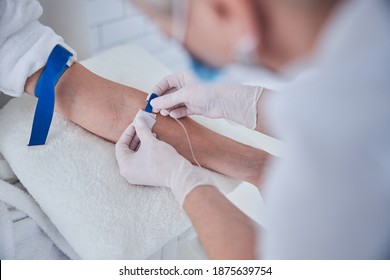 Focused image of female sitting in the cosmetic chair while receiving IV infusion in medicine center - Powered by Shutterstock