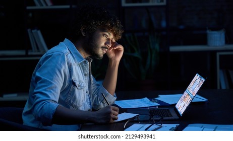 Focused indian latin business man having remote video call conference team meeting working online by distant videocall web chat late at night at home in dark office using laptop computer. - Powered by Shutterstock