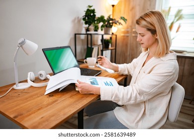 Focused individual analyzing documents while working from a cozy office space