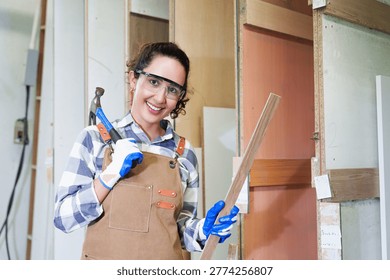 Focused individual operates CNC machine in workshop setting, utilizing wooden board for precision. Wearing protective eyewear and gloves, subject demonstrates careful attention to detail within industrial environment. scene highlights quality control and skilled operation of machinery.