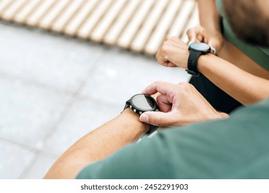 Focused individuals use smartwatches to monitor fitness, highlighting modern health technology.

 - Powered by Shutterstock