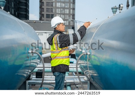 Focused industrial engineer using a calibration tool to check equipment at a manufacturing plant, ensuring operational efficiency.