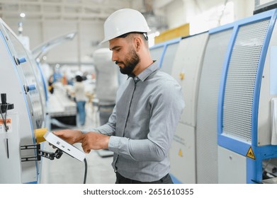 Focused industrial engineer using digital tablet, managing machinery on automated production line in modern factory, optimizing manufacturing process