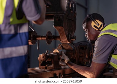 Focused industrial technician operating heavy machinery with precision. Wearing ear protection and safety gear, the professional works in a brightly lit workshop, emphasizing safety and expertise. - Powered by Shutterstock