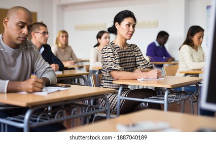 Focused Japanese Woman Listening Carefully And Taking Notes During Lecture At Adult Education Class