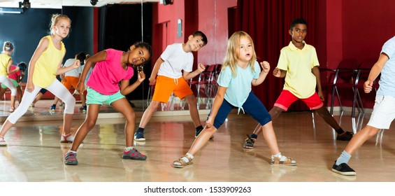 Focused Kids Studying Modern Style Dance In Class Indoors