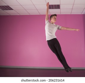 Focused male ballet dancer leaping up in the dance studio