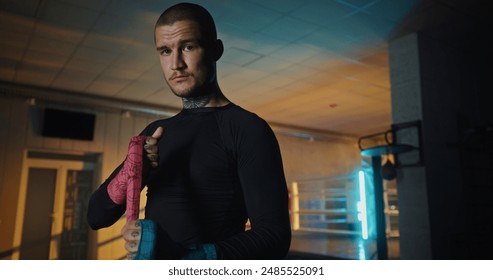 Focused Male Boxer with Tattoos Standing in Gym, Preparing Mentally Before Training - Powered by Shutterstock