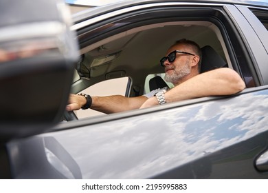 Focused Male Driver Driving A Car. Low View