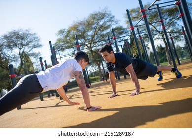 Focused Male Friends Working Out On Sunny Day. Two Men In Sportive Clothes On Open Air Sports Ground. Sport, Health, Hobby Concept