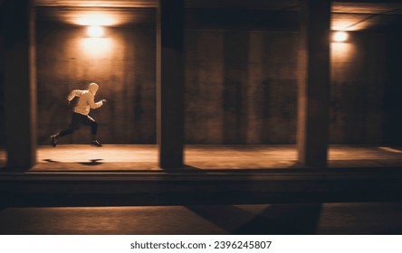 Focused Male Runner Sprinting in Urban Underpass at Night - Powered by Shutterstock