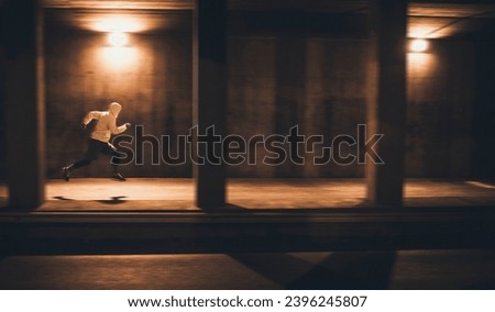 Focused Male Runner Sprinting in Urban Underpass at Night