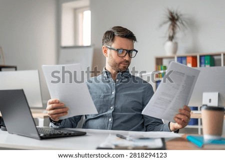 Focused Man Analyzing Documents At Home Office, Business Concept