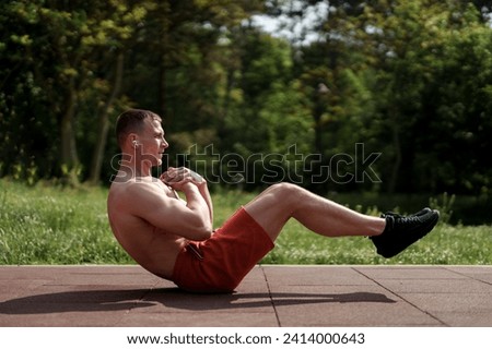 Focused man engaged in an abdominal workout in a serene park setting, emphasizing core strength