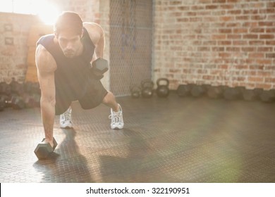 Focused Man Lifting Dumbbell At The Gym